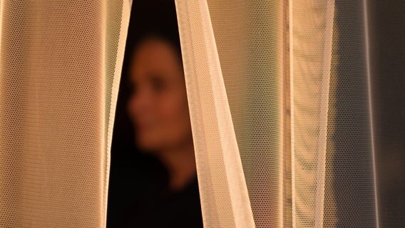 Ein Opfer von sexualisierter Gewalt steht hinter einem Vorhang. © picture alliance/dpa/Ole Spata Foto: Ole Spata
