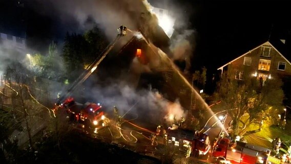 Feuerwehrleute löschen ein brennendes Haus. © dslrnews / TVNewskontor 